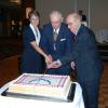 Brenda Bess, Reg Fansler, and Horace Berry cut the anniversary cake.